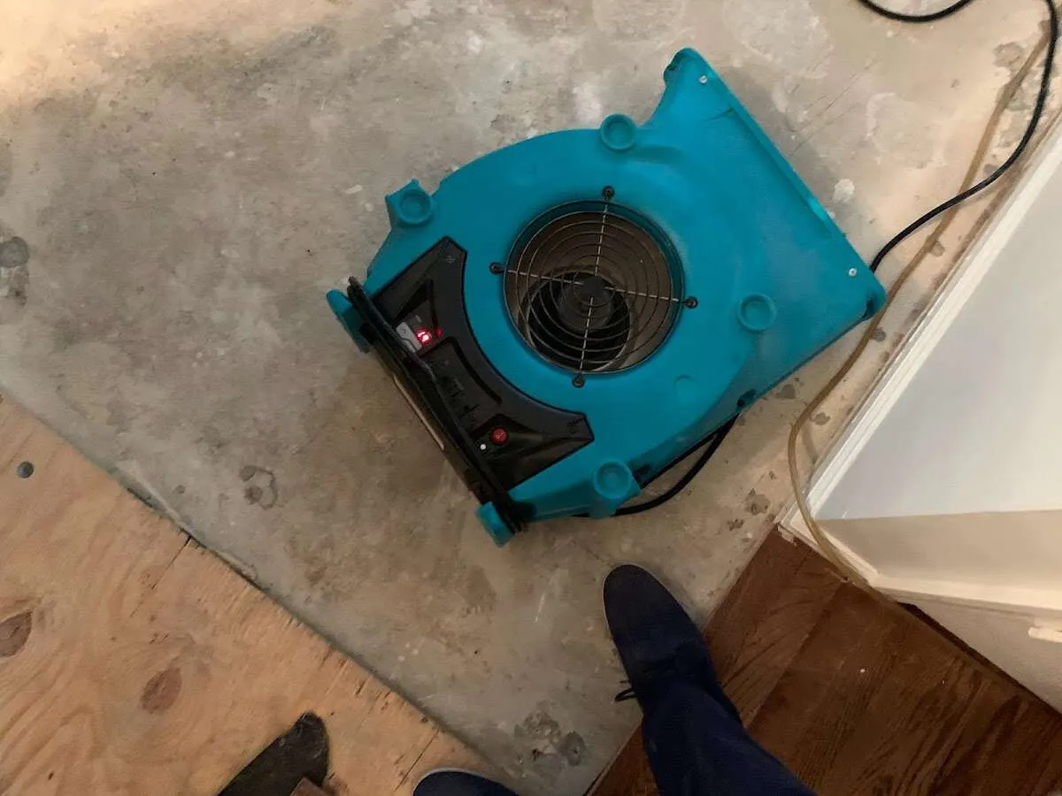 Air mover drying subfloor during Commercial Water Damage Restoration in Arkansas City